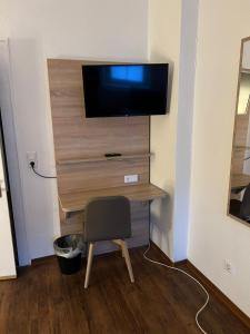 a desk with a television and a chair in a room at Tilla's Hof in Hamm