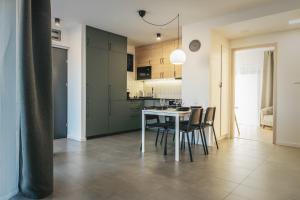 a kitchen and dining room with a table and chairs at Nádas Apartman in Szeged