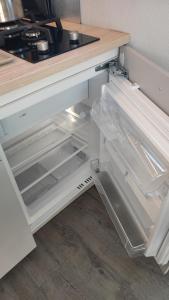 un frigorifero vuoto con la porta aperta in una cucina di Houseboat Water Boy apartament pływający dom na wodzie łódź a Uraz