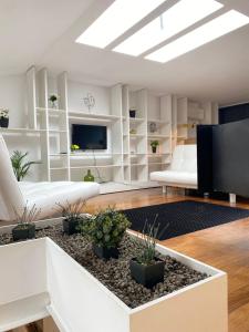 un soggiorno con mobili bianchi e TV a schermo piatto di Casa da Avenida VILLA INN a Braga
