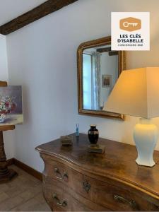 a lamp on top of a dresser with a mirror at Maison Mayeras, 3 ch in Razès