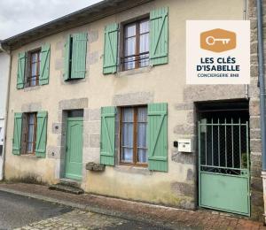 a building with green shuttered windows and a door at Maison Mayeras, 3 ch in Razès