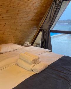 een slaapkamer met een bed met handdoeken erop bij Potcoava Dunarii in Suhaia