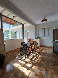 a kitchen with a table and chairs in a room at Casa de Praia in Ubatuba