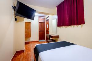 a hotel room with a bed and a flat screen tv at Hotel Italia II in Chiclayo