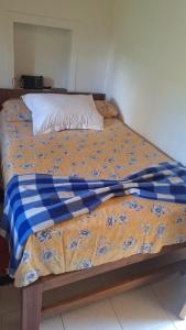 ein Bett mit einer blauen und weißen Decke drauf in der Unterkunft Finca Campestre Villa Gladys in Guatapé
