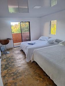 1 Schlafzimmer mit 2 Betten und einem Fenster in der Unterkunft Finca Campestre Villa Gladys in Guatapé