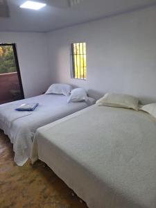2 Betten nebeneinander in einem Zimmer in der Unterkunft Finca Campestre Villa Gladys in Guatapé