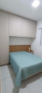 a bedroom with a blue bed and white cabinets at Apartamento Atos Ubatuba in Sao Paulo