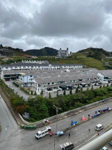 un grand bâtiment avec des voitures garées dans un parking dans l'établissement Alliv NSF Studio & 1 Bedroom Apartment Stay, à Brinchang