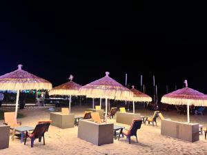 een groep stoelen en parasols op een strand bij Baga beach front in Baga