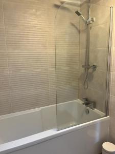 eine Badewanne mit Glastür im Bad in der Unterkunft Wharf Cottage in Coalbrookdale