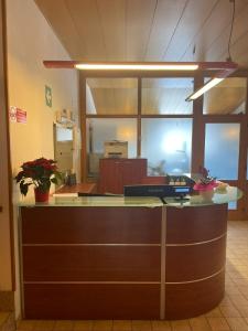 an office cubicle with a reception counter with plants at Hotel Tarvis in Tarvisio