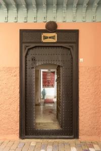 Una puerta en una pared con un cartel. en Riad Hayati, en Marrakech