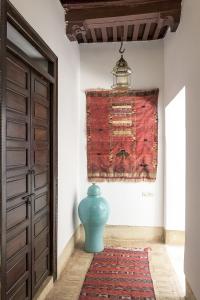un jarrón azul sentado en una alfombra junto a una puerta en Riad Hayati, en Marrakech