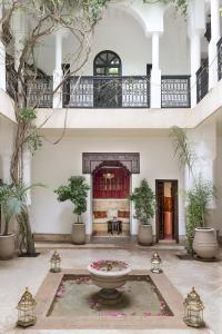 un patio con una fuente y macetas en Riad Hayati, en Marrakech