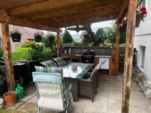 um pátio com uma mesa e cadeiras sob uma pérgola em Marilyn em Niederwil