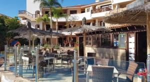 サンミゲル・デ・アボナにあるBiB Pool Side Apartment & Ocean Viewの建物の前にあるレストラン(テーブルと傘付)
