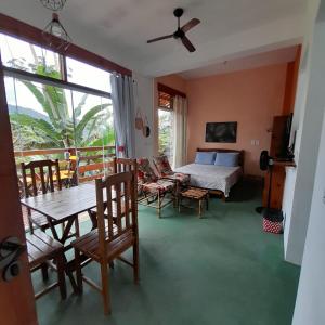 um quarto com uma cama, uma mesa e cadeiras em La Casa Rozada Prumirim em Ubatuba