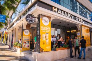 people standing outside of a coffee shop on a street at HALLEY OTEL in Denizli