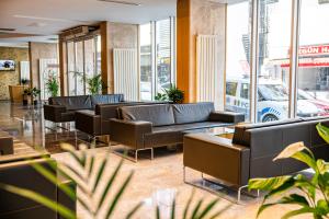 a waiting room with couches and tables and windows at HALLEY OTEL in Denizli