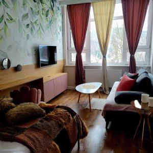 a living room with a bed and a couch at Apartament By Miło Było in Ustroń