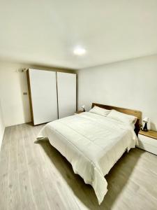 ein weißes Schlafzimmer mit einem großen weißen Bett. in der Unterkunft Appartamento Ali&Dome centralissimo in Ancona