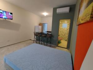 a room with a bed and some bar stools at Apartamentos Kairos in Ubatuba