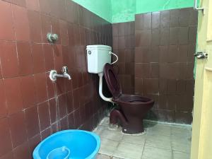 a bathroom with a toilet and a bucket in it at The Kaya Rockview Trichy in Tiruchchirāppalli +14 photos