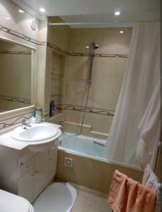 La salle de bains est pourvue d'une baignoire, d'un lavabo et d'une douche. dans l'établissement Cozy Beach House, à Santa Cruz