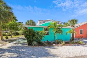 una casa colorida con palmeras delante en Beach Life 2, en St Pete Beach