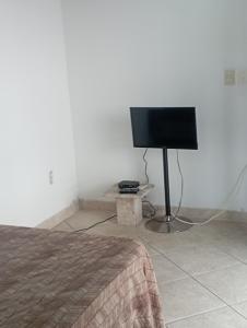 1 dormitorio con 1 cama y TV de pantalla plana en Suíte Prainha, en Río de Janeiro