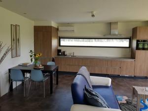 a living room with a blue couch and a table at Sfeervol chalet midden in de natuur in Halle