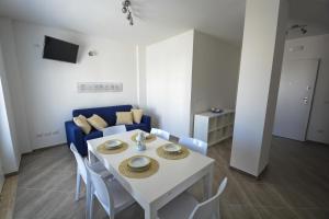 uma sala de estar com uma mesa e um sofá azul em Hypogeum Suites & Apartments em Otranto