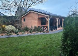 una pequeña casa con un patio de hierba delante de ella en Het Blij Hen, en Oudenbosch