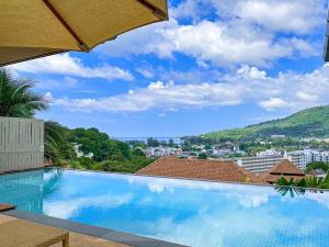 uma grande piscina com vista para a cidade em Villa Tantawan Resort - Private Pool Villas em Praia de Kamala
