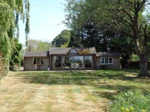 a house with a large yard in front of it at Idyllic Log Cabin Near Stratford upon Avon in Stratford-upon-Avon