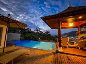 a house with a swimming pool and a deck at Villa Tantawan Resort - Private Pool Villas in Kamala Beach