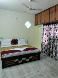 a bedroom with a bed in a room with curtains at JK Home Stay in Tirupati
