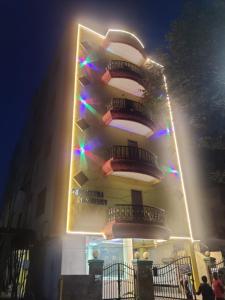 a tall building with lights on it at night at JK Home Stay in Tirupati