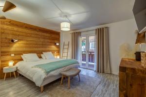 um quarto com uma cama e uma parede de madeira em Les Chalets de La Clusaz - Appartement le Yeti em La Clusaz