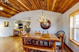 a dining room with a wooden table and a ceiling at Pine Woods Cabin in McHenry