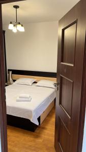 a bedroom with a bed and a open door at Life Energy in Voluntari