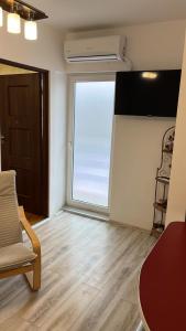 sala de estar con ventana grande y silla en Life Energy, en Voluntari