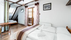 ein Schlafzimmer mit einem großen weißen Bett in einem Zimmer in der Unterkunft Apartament Retro - Malownicze Osiedle Podgórze in Szklarska Poręba