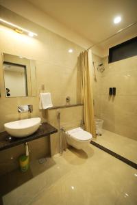 a bathroom with a sink and a toilet and a shower at Maruti Group of Hotels - The Shivam in Nāthdwāra