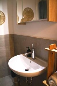 y baño con lavabo blanco y espejo. en Geräumige und stylische Wohnung mit Weitsicht, en Huttwil