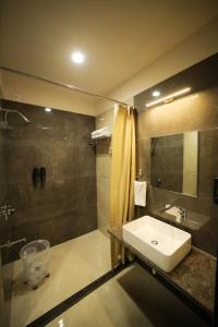 a bathroom with a sink and a shower at Maruti Group of Hotels - The Shivam in Nāthdwāra