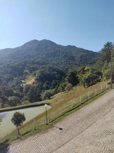 eine Straße neben einem Fluss mit einem Berg in der Unterkunft Férias no Capivari in Represa Capivari