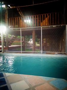 a fence around a swimming pool at night at บ้านสวนชนะจน in Fang
